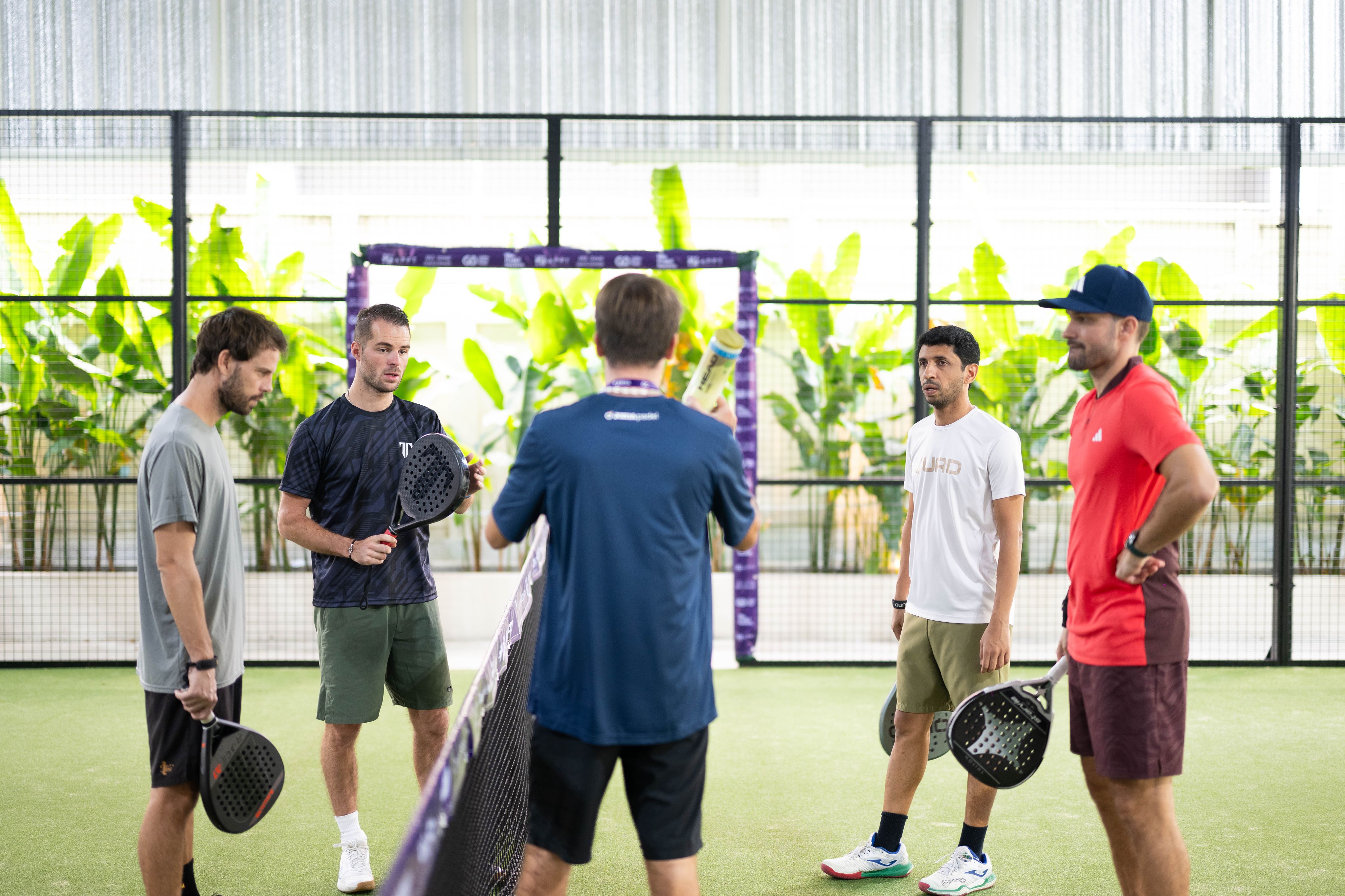 Group of men listening to a padel coach