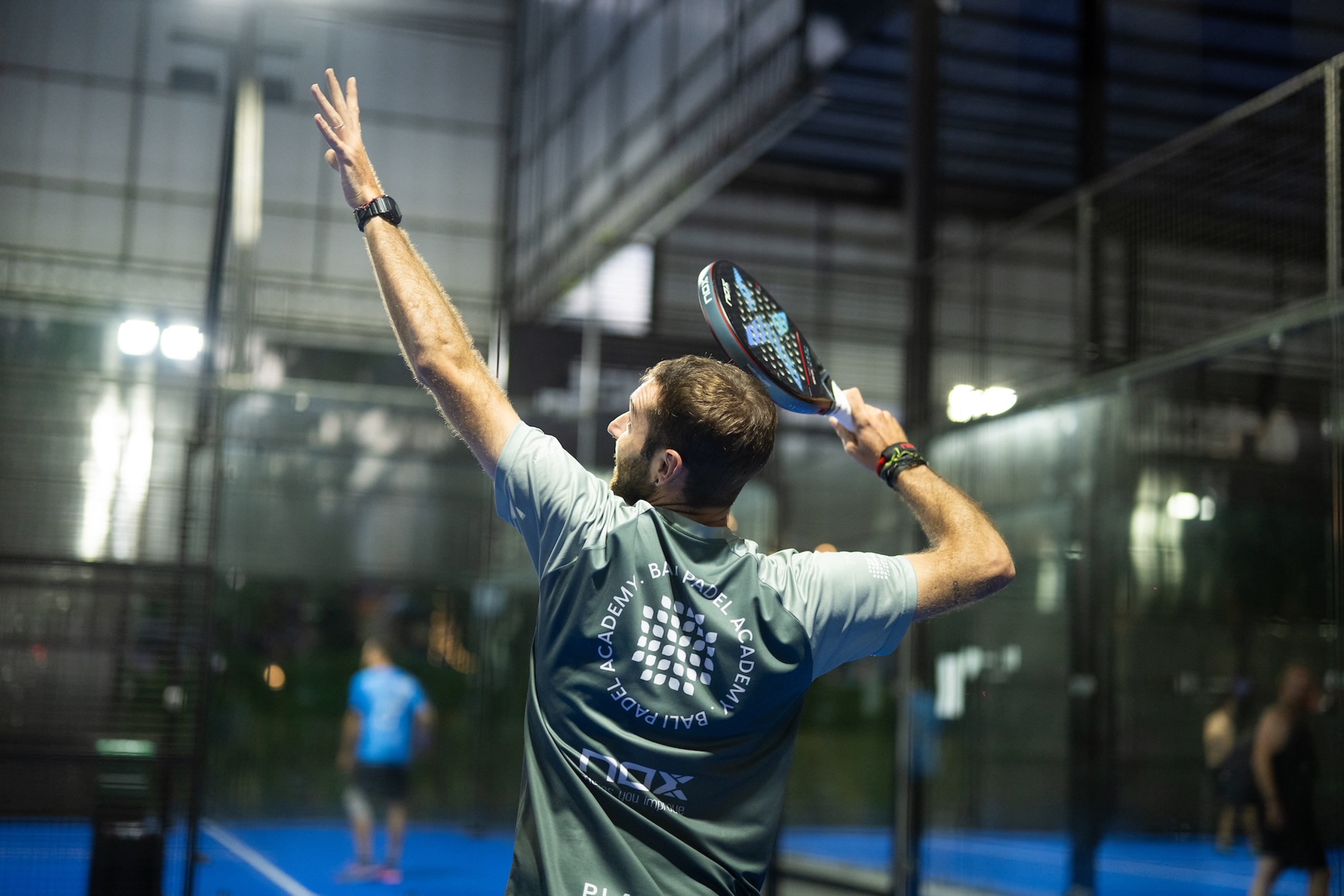 Padel player preparing to smash the ball on an indoor court