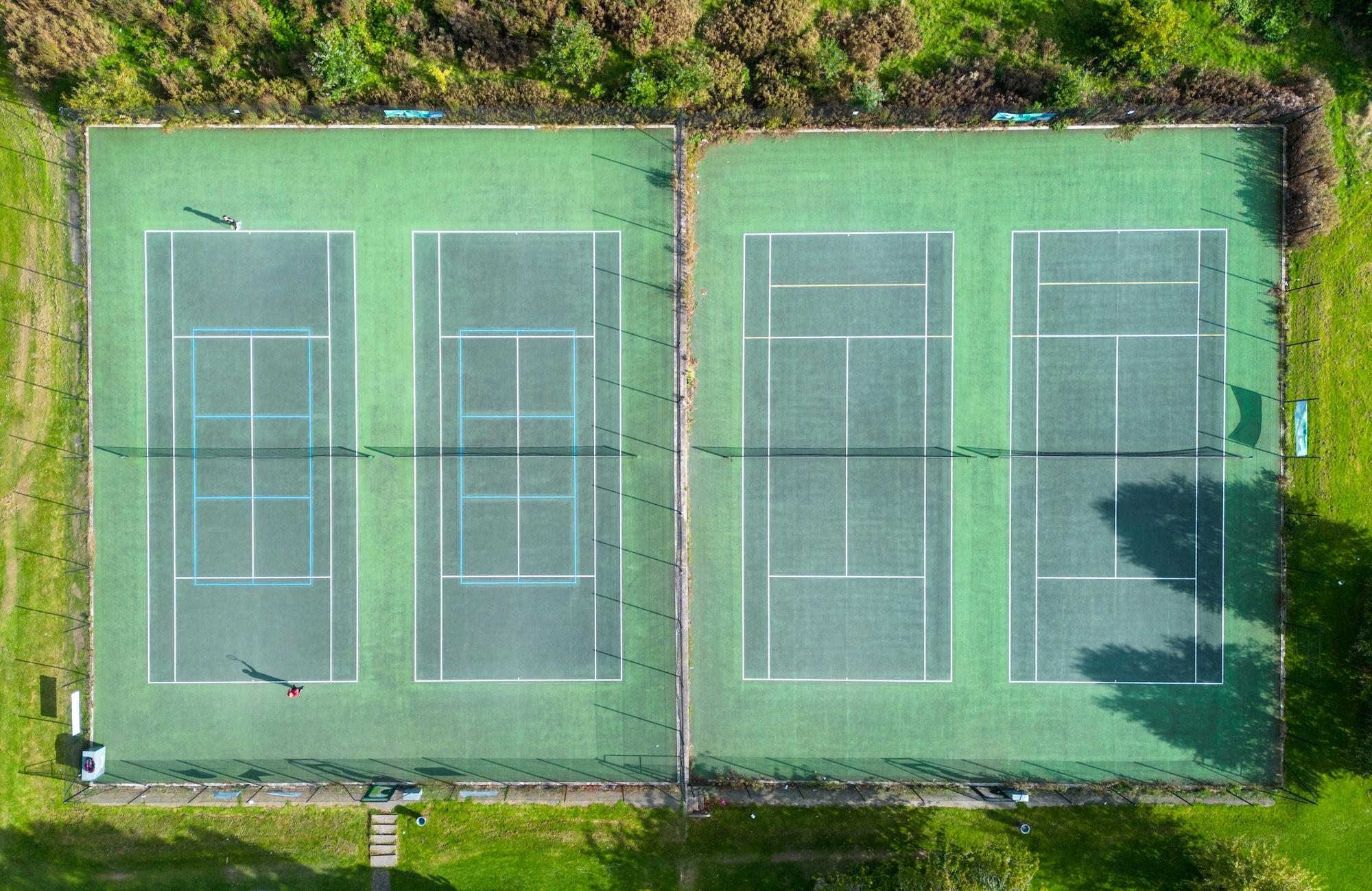 Aerial view of a tennis facility with four courts