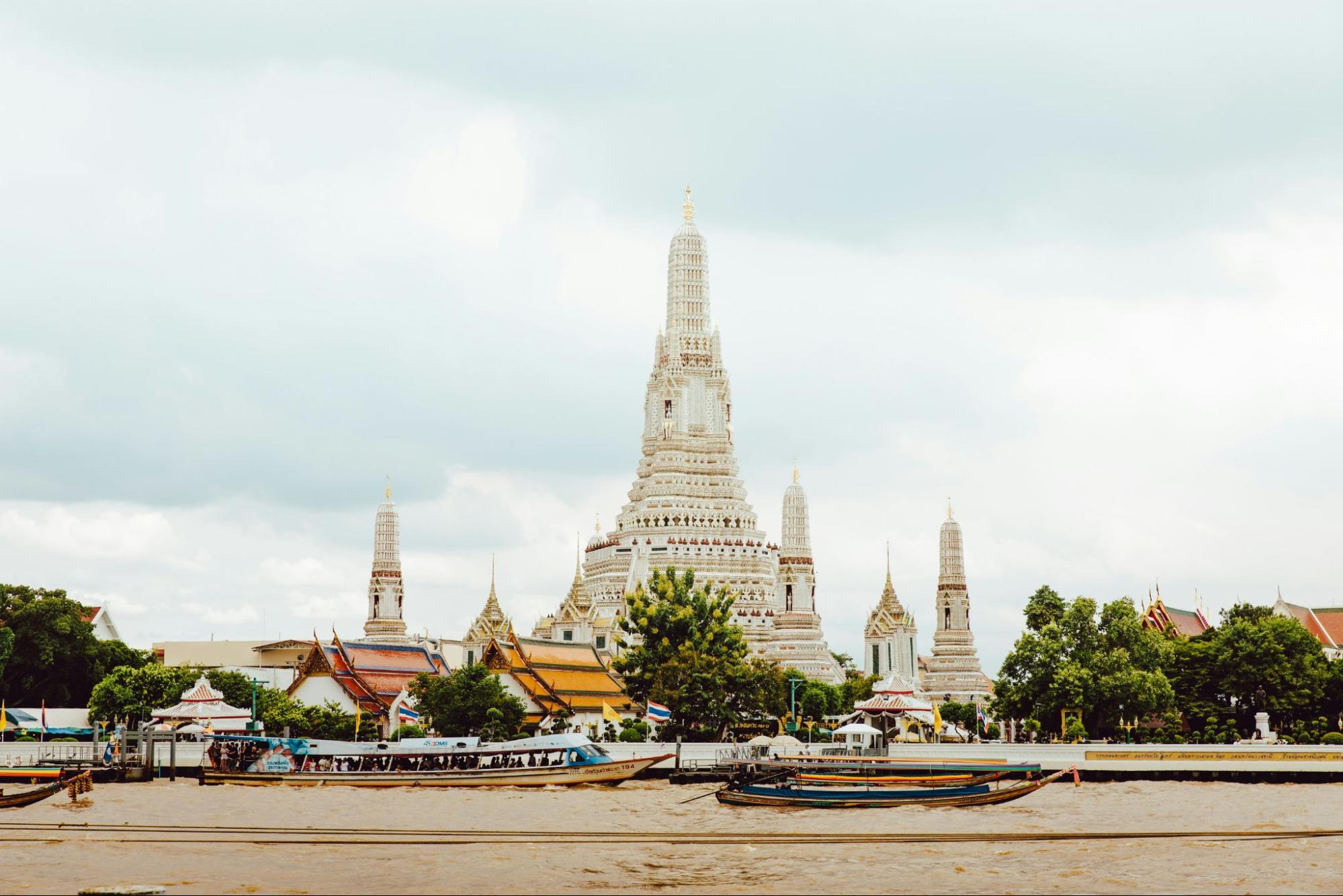 Riverside view of Wat Arun with boats in the foreground